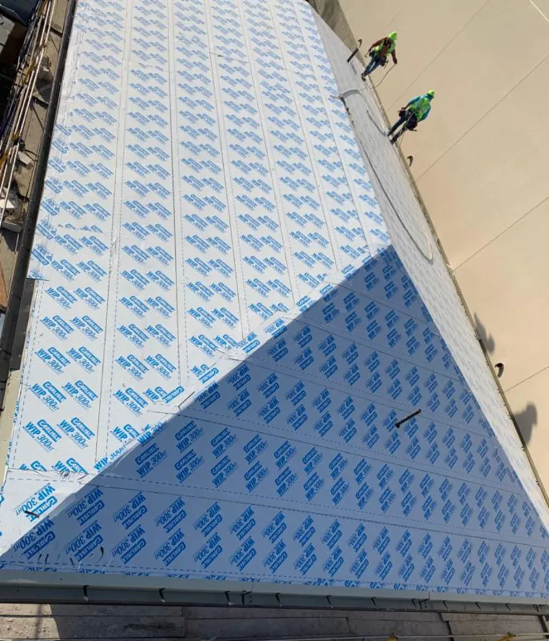 Professional roofers installing underlayment on a metal roof in Del City